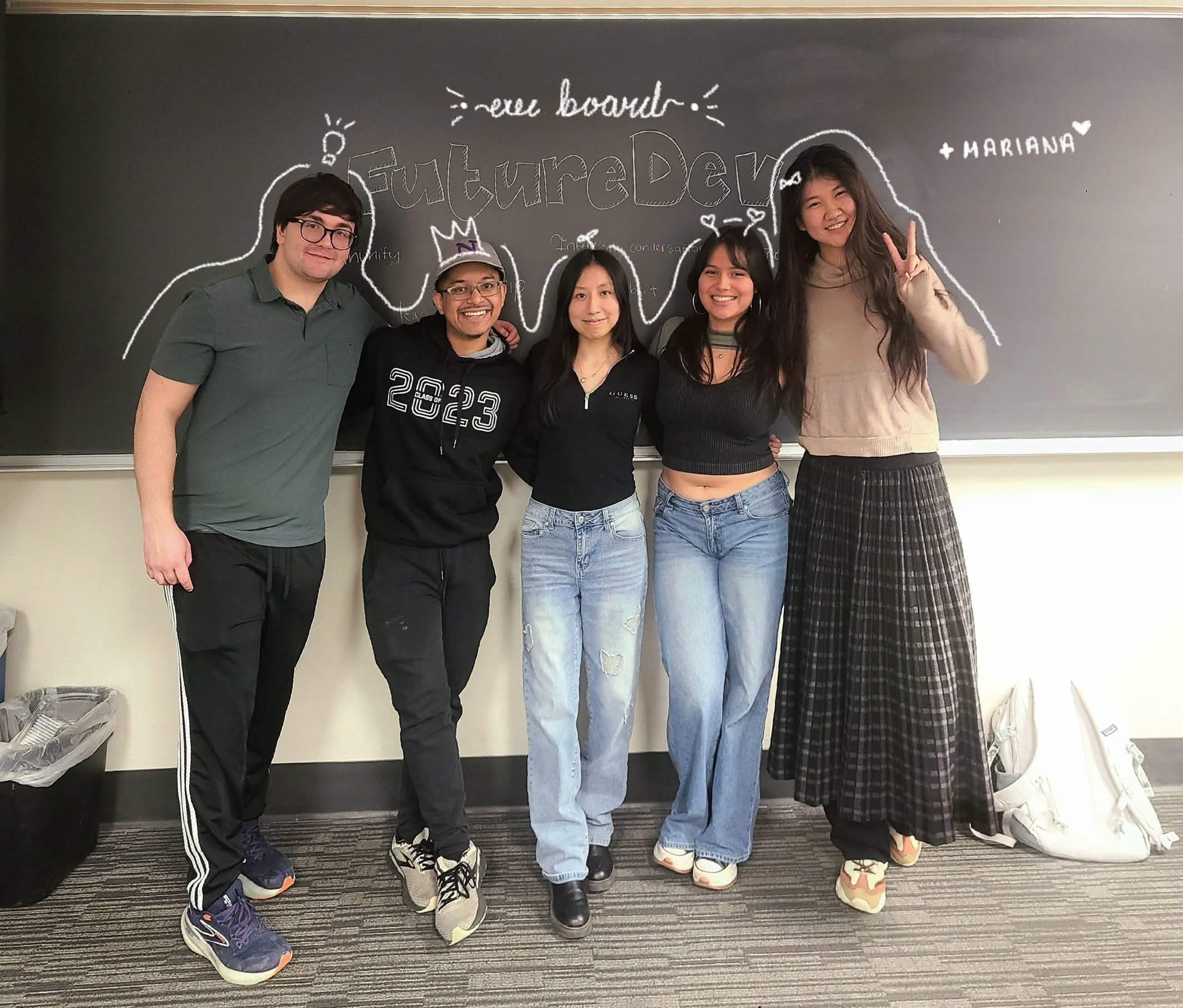 FutureDev's executive board posing together in front of a chalkboard